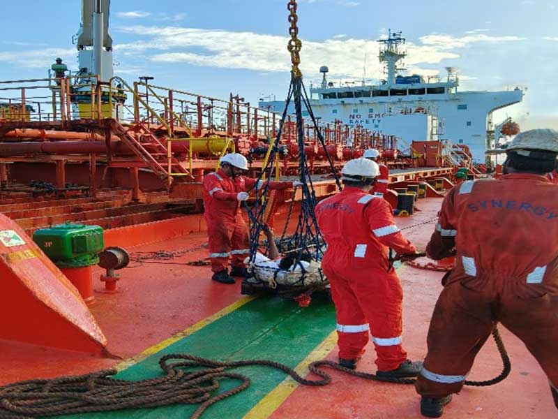 Injured fisherman being transferred in a stretcher basket from a Sri Lankan fishing boat to the GEMINI PEARL during the rescue operation.