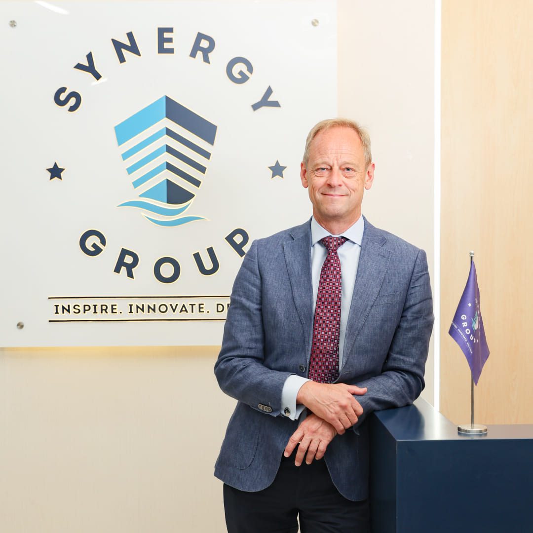 Jesper Kristensen, Group CEO of Synergy Marine Group, photographed in front of a wall featuring the company logo