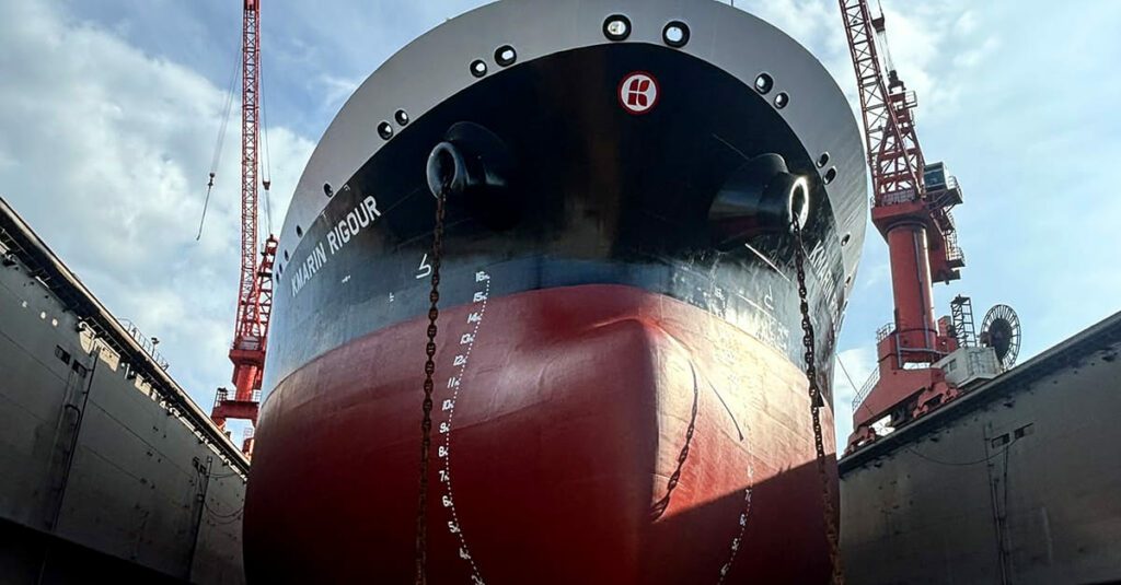 Large vessel KMARIN RIGOUR sitting on blocks during shipyard dry docking maintenance
