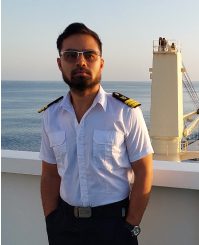 Professional portrait of Joebert Canja, Chief Officer of AMIS XCEL, standing in uniform on the ship's deck with the ocean background.
