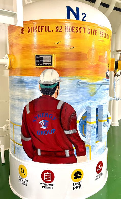A crew-created safety mural on the vessel's nitrogen tank, using bold colour, scale and strong visual emphasis to make enclosed-space awareness and safe working practices immediately visible.