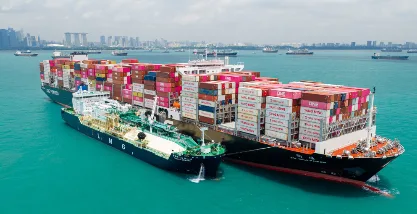 Aerial view of YM Willpower, a 15,500 TEU LNG dual-fuel container vessel operating at sea.